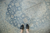 Distressed vintage Oushak rug with pale teal, ivory Rococo floral pattern and feet.