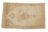 Distressed vintage Oushak rug mat with ivory medallion, coffee brown hook-latch motifs, zig-zag border, 1'9