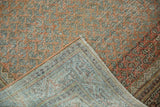 Distressed vintage Mir Serbend rug folded, revealing worn chestnut terra cotta pile and woven foundation.