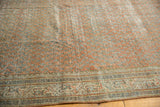 Distressed Mir Serbend rug, showcasing chestnut terra cotta boteh and geometric border.