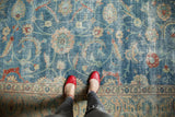 Decorative distressed sky blue Tabriz carpet field with sprawling vinery and floral palmettes.