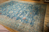 Distressed sky blue field with sprawling vinery and beige floral palmette border.