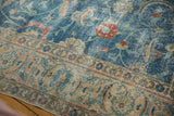 Distressed blue field with scrolling vinery, meeting the beige Tabriz border.