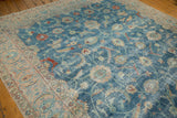Distressed Tabriz carpet corner, with faded blue field, scrolling vinery, and pale floral border.
