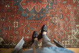 Antique Serapi carpet's madder red field with sky blue and ivory geometric motifs showing even wear.