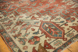 Fragmented antique Serapi carpet detail: playful rust, blue, ivory geometric motifs, knot head wear.
