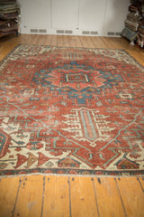 Antique Serapi rug's secured bottom edge, featuring madder red-rust, blue, ivory geometric patterns and pile wear.