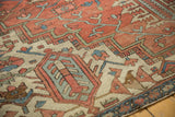 Detail of antique Serapi carpet's geometric design, madder red field, and time-softened pile.