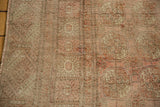 Distressed low pile of a Bokhara rug with dusty rose and ivory floral guls.