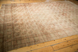 Distressed vintage Bokhara rug corner featuring intricate geometric border and subtle blush.