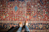 Vintage Heriz rug field detail with geometric patterns, cherry red, and visible wear.