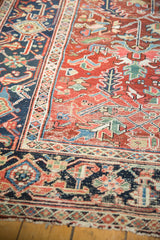Vintage Heriz carpet: cherry red field, rectilinear design, navy blue geometric border.