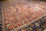 Densely ornamented vintage Heriz rug with intricate geometric patterns and time-softened tones.