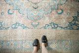 Distressed vintage Khorassan carpet with soft pale apricot, sky blue, and beige palmettes.