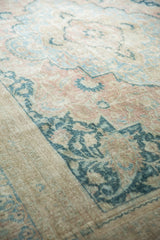 Distressed vintage Khorassan carpet showcasing faded blue and apricot floral motifs on worn beige.