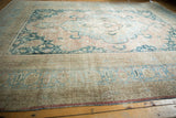Distressed pile texture on vintage Khorassan rug corner, showing faded apricot, sky blue motifs.