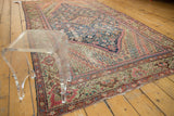 Antique Fereghan carpet corner with diagonal floral design in blush, rust, and pale green.
