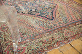 Antique Fereghan carpet with navy medallion corner, blush Herati field, and visible wear.