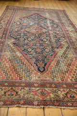Fereghan carpet's intricate floral end border, blush, pale green, and red tones, with secured fringe.