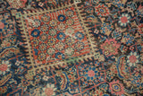 Textural detail of antique Fereghan carpet's Herati motif, showing navy, blush, and pale green with even wear.