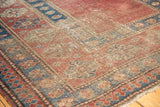 Patinaed madder red field, indigo blue patterned border, and geometric pawn motif on antique Caucasian rug.