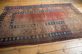 Antique Caucasian carpet's distinct red and blue pawn motif border, with time-softened madder field.