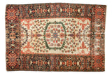 Antique Persian Farahan Sarouk rug with a serrated green medallion, tree-of-life motifs on an ivory field, and a wide navy border, measuring 4'3