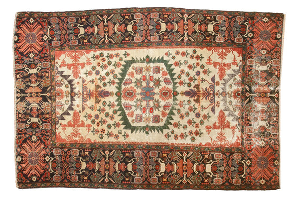 Antique Persian Farahan Sarouk rug with a serrated green medallion, tree-of-life motifs on an ivory field, and a wide navy border, measuring 4'3