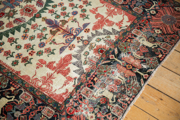 Corner close-up of an antique Farahan Sarouk rug showing the intricate planter border and serrated patterns.
