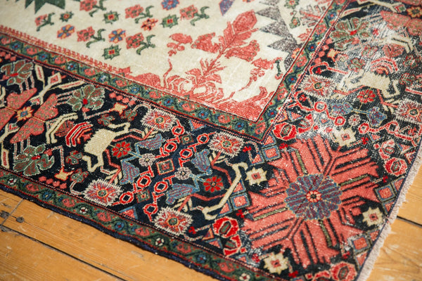 Angled view of the antique Farahan Sarouk rug's corner, showing detailed border patterns and low pile wear.