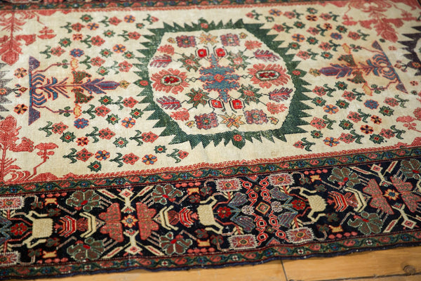 Angled view of Farahan Sarouk rug with its green serrated medallion and wide potted planter border.