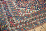 Vintage Shiraz carpet corner, intricate multi-borders with geometric and floral motifs, worn pile.