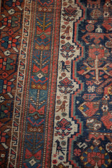 Intricate serpents and animals in navy, brick red, ivory on a vintage Shiraz carpet.