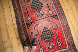 Antique Karabagh runner's germinating tree motif and birds on a faded fuchsia red field.