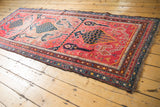 Antique Karabagh runner corner showing rich navy border, soft fuchsia field, and stylized bird motifs.