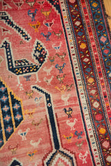 Faded fuchsia field showing stylized fowl, birds, and intricate navy, red, blue borders.