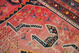 Close-up of an antique Armenian Karabagh runner's faded blush field with colorful folk animal motifs.