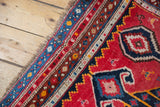 Antique Karabagh runner border with vibrant fuchsia, navy blue, and ivory geometric patterns.