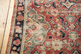 Distressed Mahal rug pile showing brick red, navy, green floral patterns and surface wear.