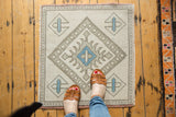 Distressed Oushak rug's ivory field, beige border, and powder blue geometric motifs.