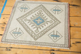 Oushak rug corner showing cross-hatch geometric border, powder blue motif, and pale rose selvage.