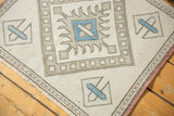 Vintage distressed Oushak rug edge displaying ivory, powder blue geometric and cross-hatch border.