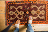 Saturated plum and tangerine orange crab motifs on a vintage Oushak rug.