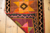 Hand-knotted vintage Oushak rug corner with plum reverse, zigzag border, and red binding.