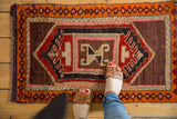 Vintage Oushak rug's concentric medallion and barber pole border in red, mauve, tangerine.