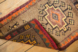 Folded corner of vintage Oushak rug showing thick camel pile, dark woven back, and plum orange edge.