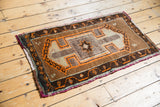 Vintage Oushak rug featuring geometric medallion and borders in camel brown, tangerine, and chocolate tones.