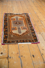 Thick pile of vintage Oushak rug featuring tangerine serpent motifs and brown pearl-and-vine border.