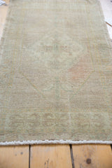 Distressed vintage Oushak rug showing subtle floral motif, even pile wear, and pale blush tones.