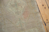 Vintage distressed Oushak rug's original side cord selvage and softly faded pattern.